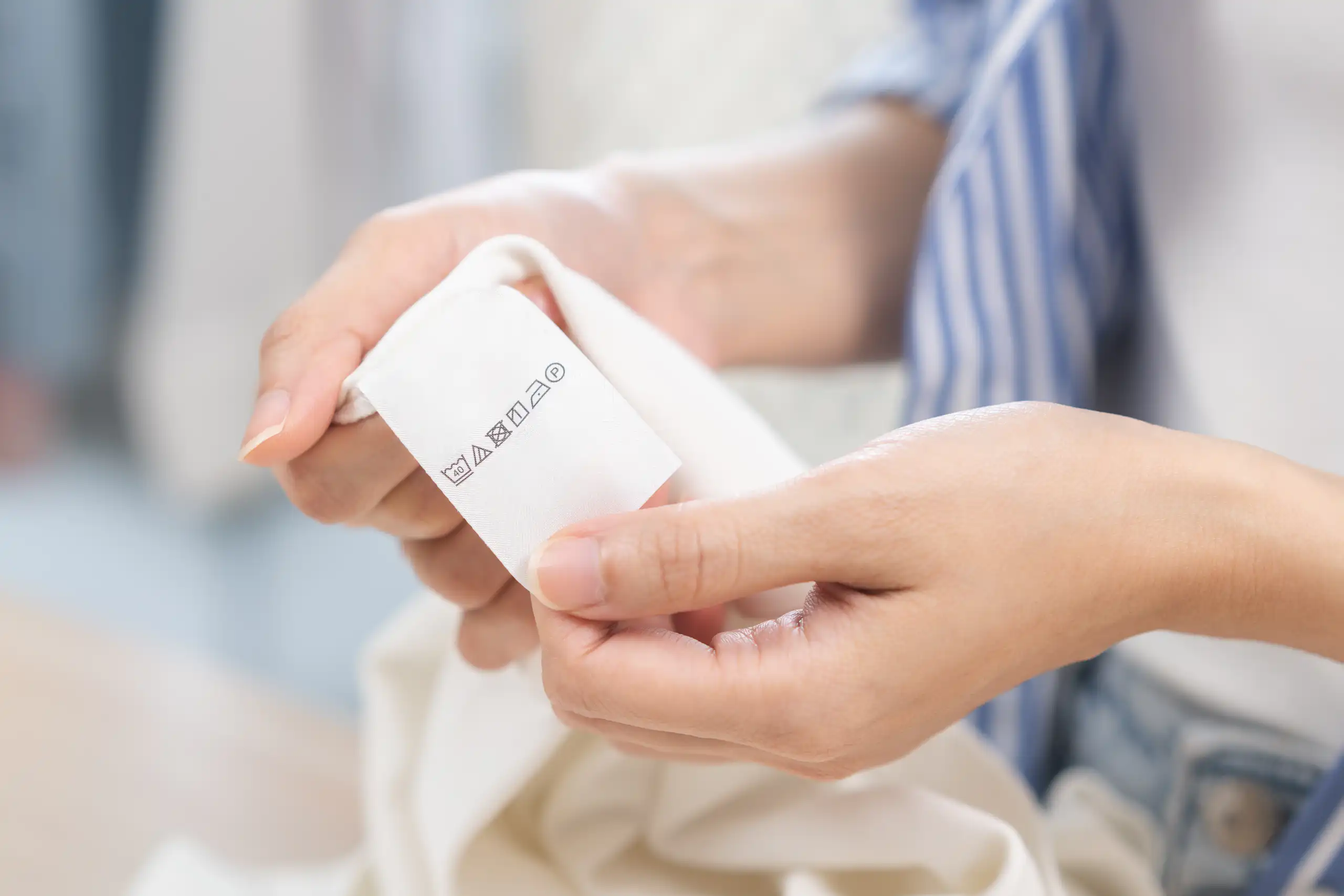 woman holds washing label on clothes