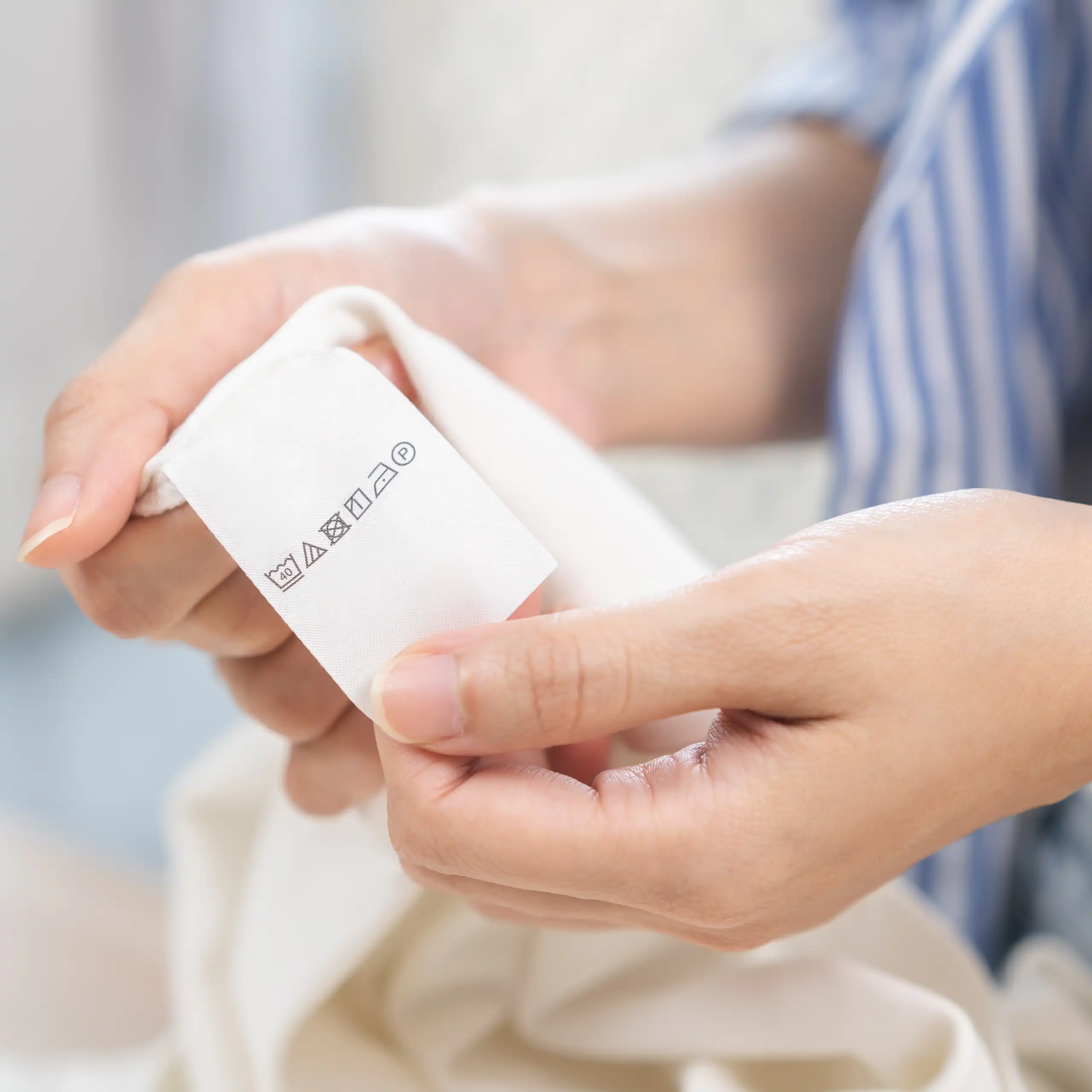 woman holds washing label on clothes