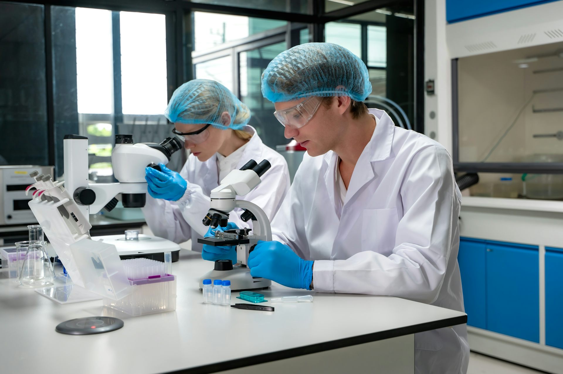 Deux chercheurs, un homme et une femme, en train de travailler dans un laboratoire de recherche.