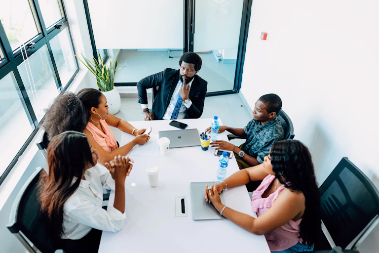 View from above of people seated at a table in an office environment