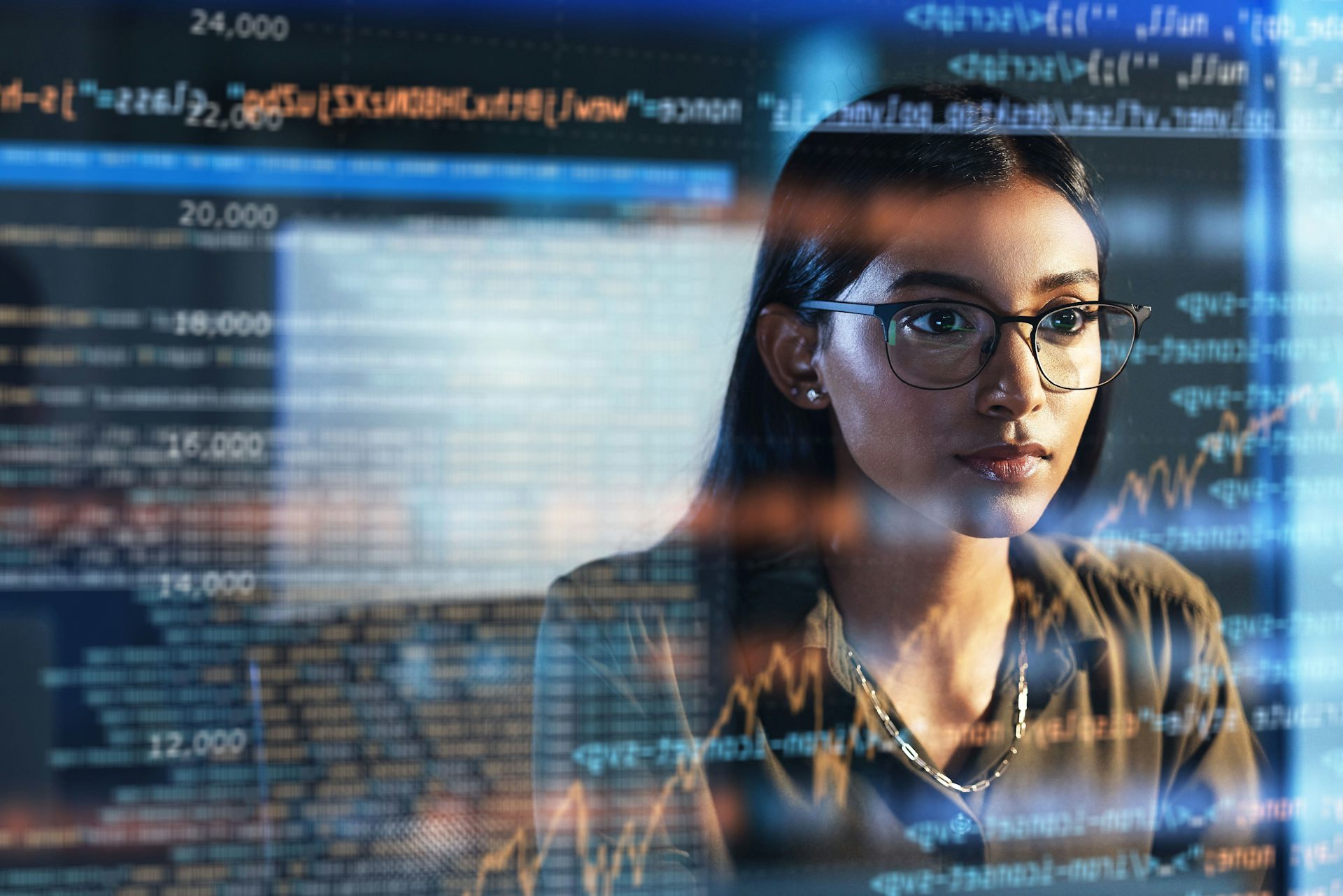 Femme devant un écran numérique avec des lignes de code.
