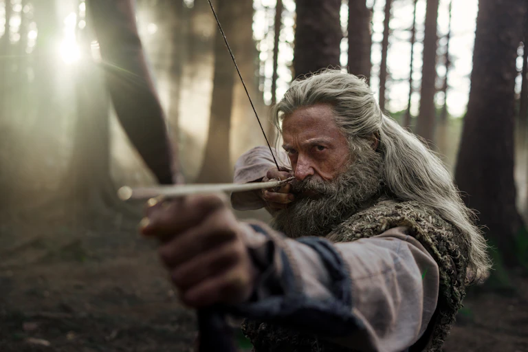Hugh Jackman as Robin Hood with a bow and arrow.