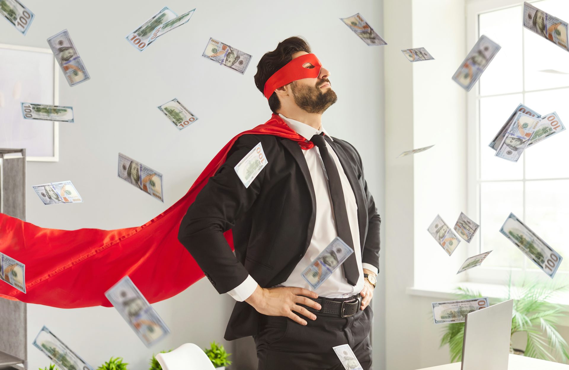 Un homme en costume de superhéros sous une pluie de billets de banque.