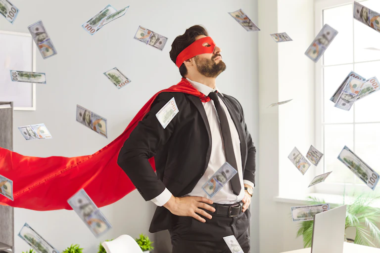 Un homme en costume de superhéros sous une pluie de billets de banque.