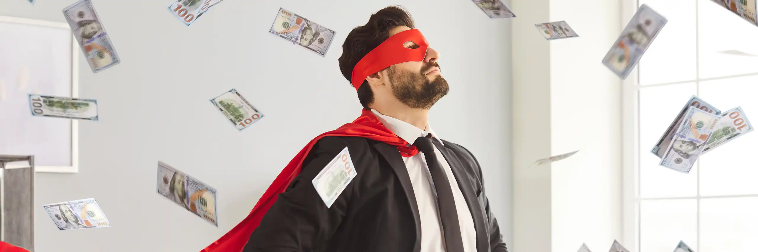 Un homme en costume de superhéros sous une pluie de billets de banque.