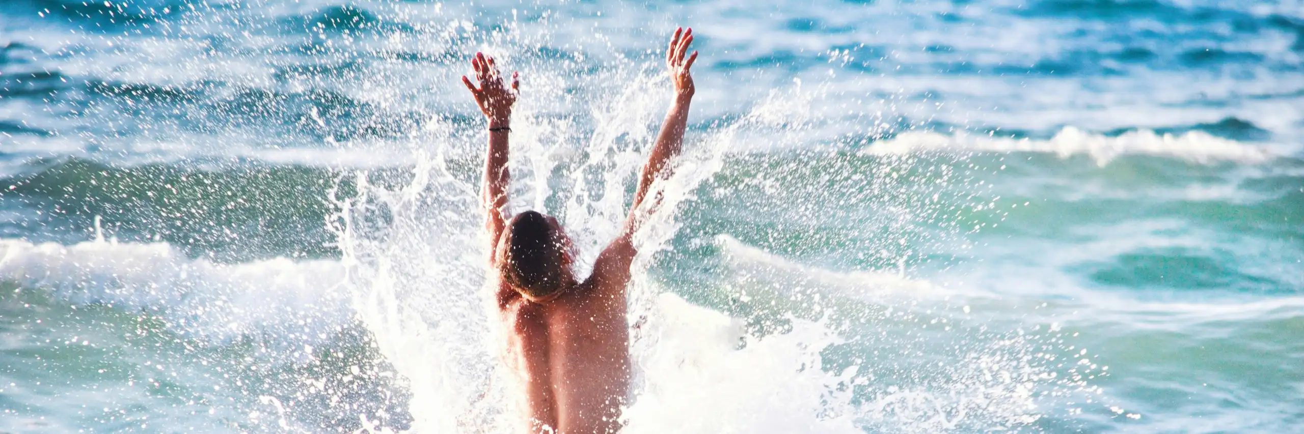 Photo d’un adolescent en train de sauter dans les vagues