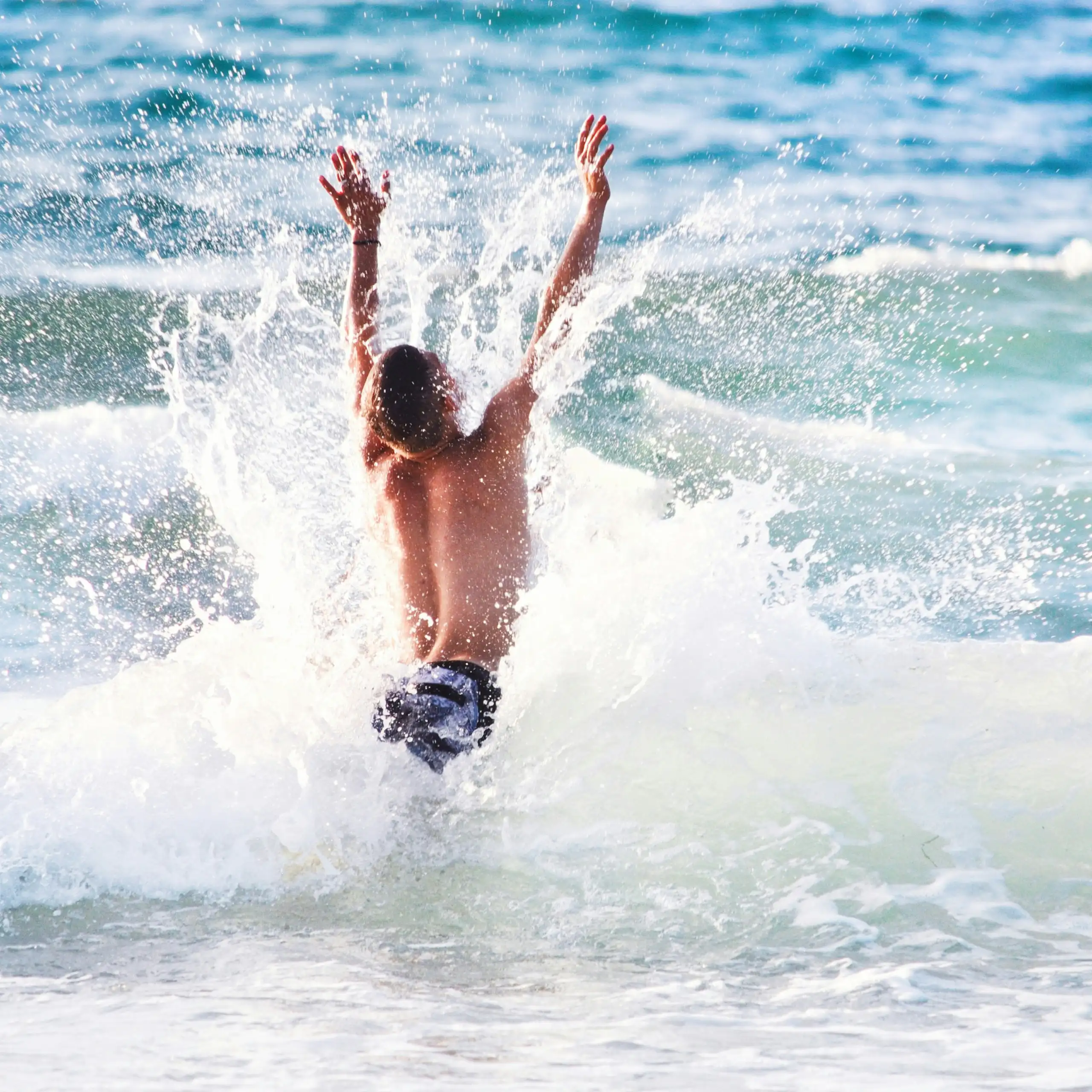 Photo d’un adolescent en train de sauter dans les vagues