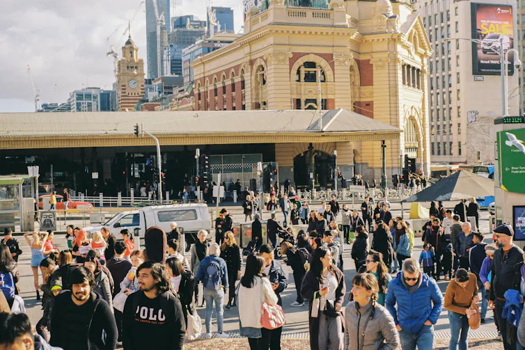 A large crowd of people around Flinders Street Station in Melbourne.