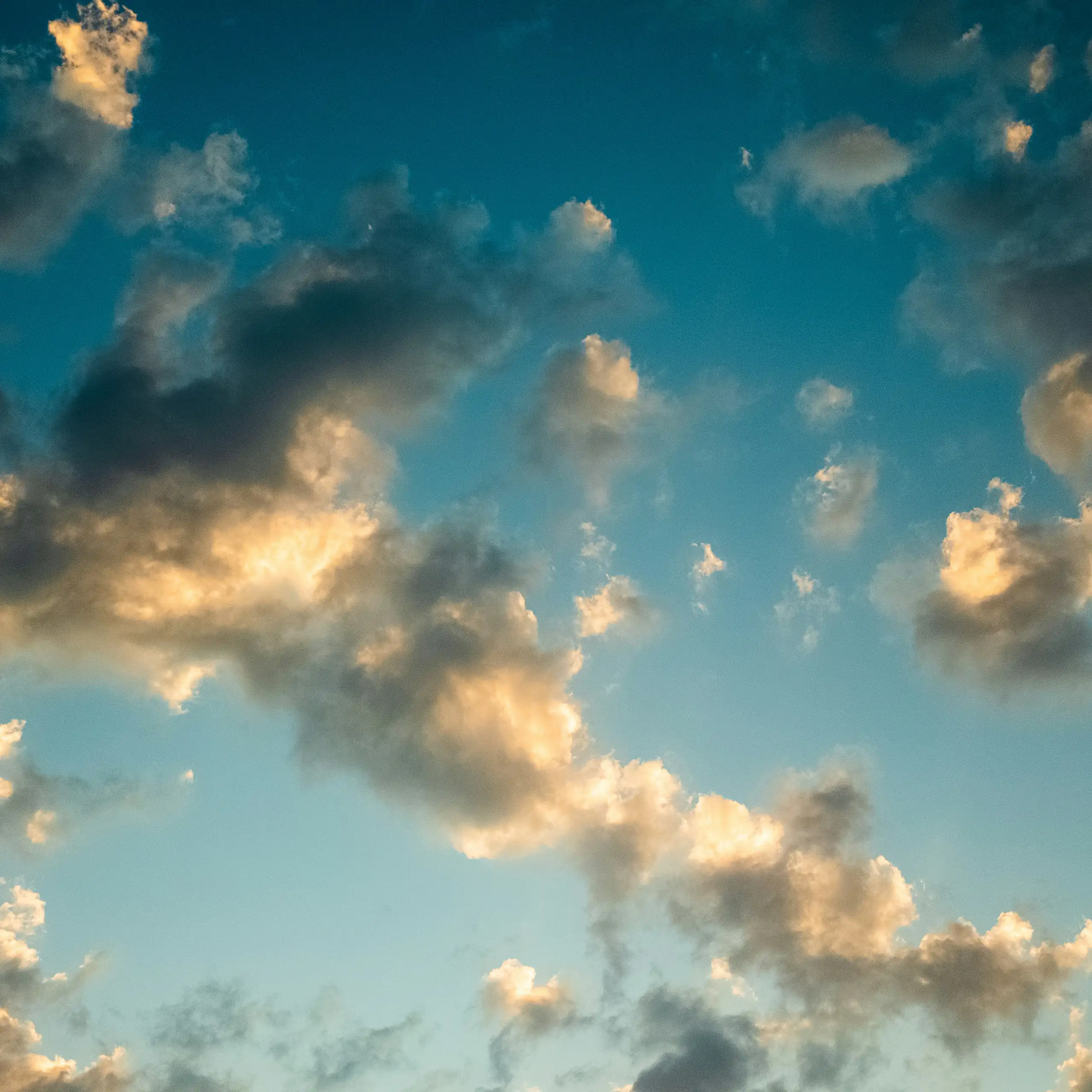 Sunlit clouds against a blue sky