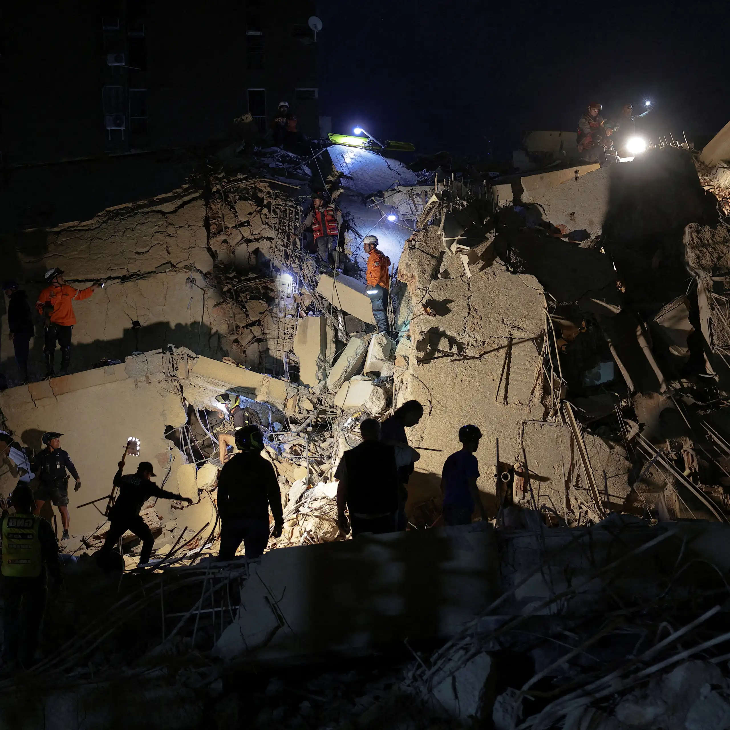 Servicios de emergencia trabajan en un edificio derrumbado de Caracas la noche del 24 de junio.