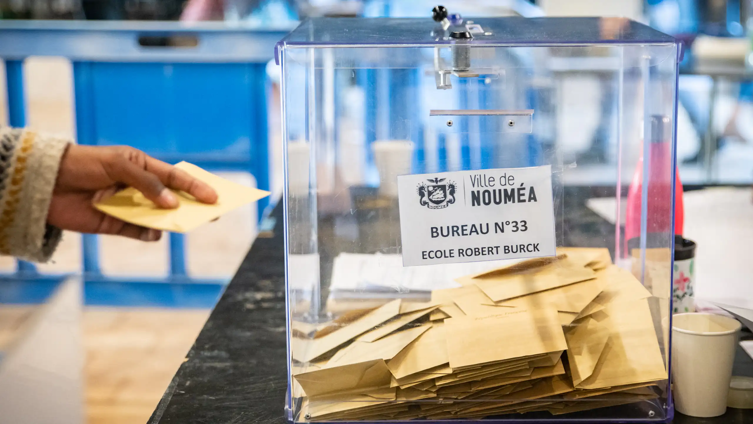 image d'une urne et d'une main déposant un bulletin de vote