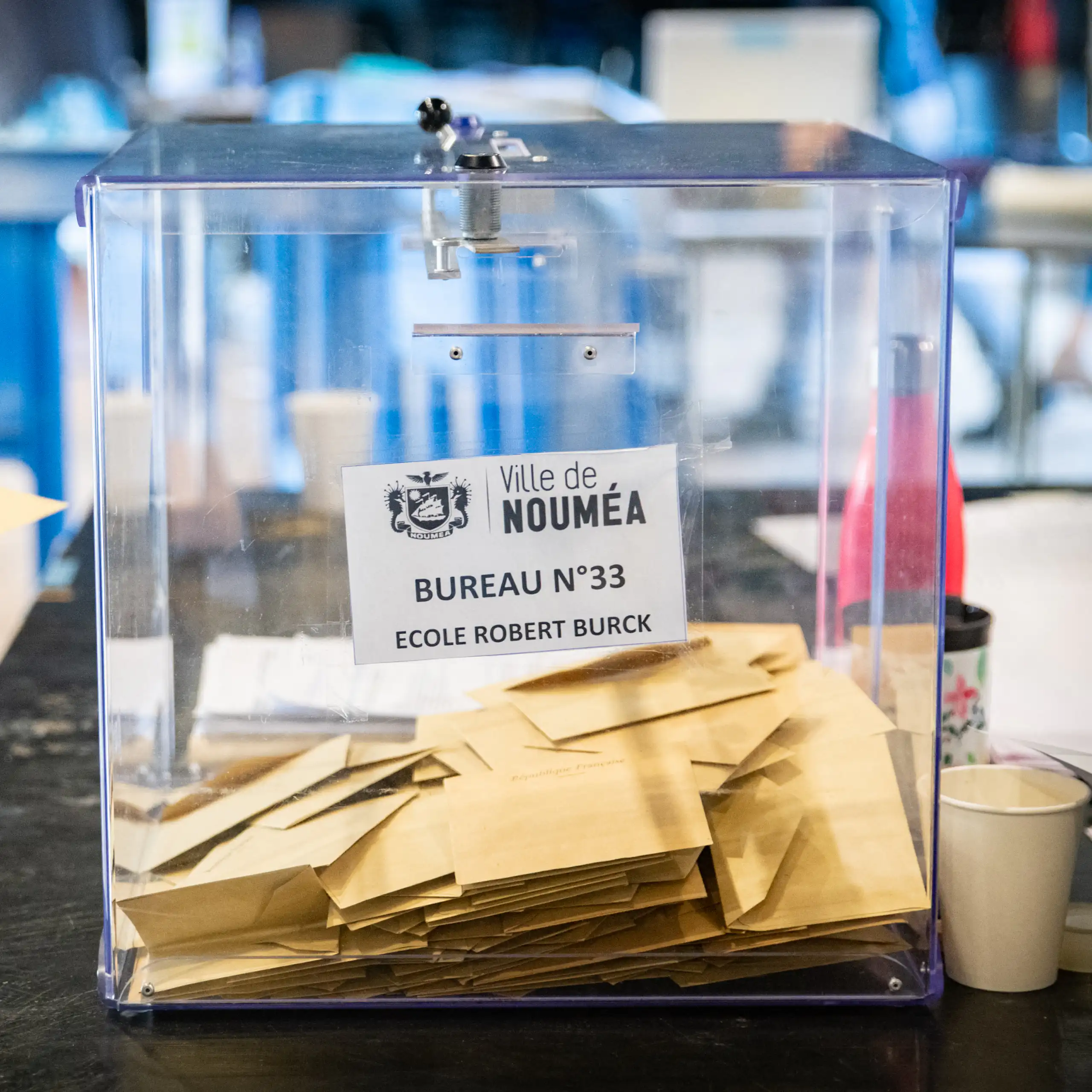 image d'une urne et d'une main déposant un bulletin de vote