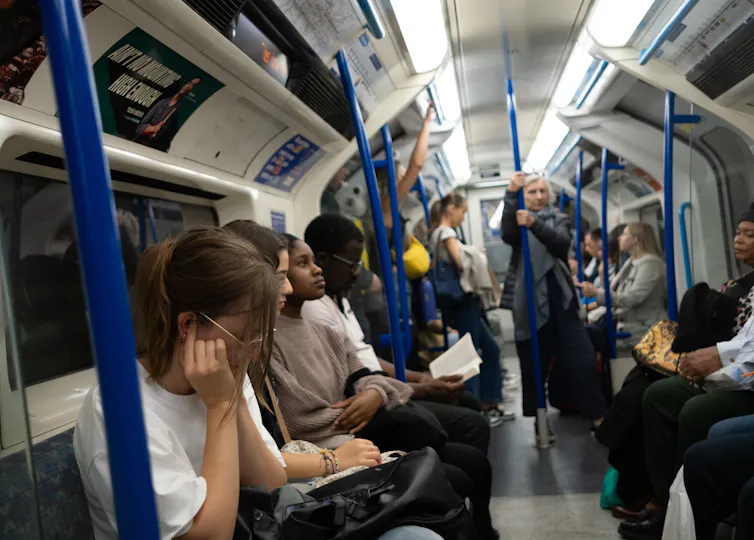 A woman puts her fingers in her ears as protection from the noise of the Victoria Line Tube Train in London.