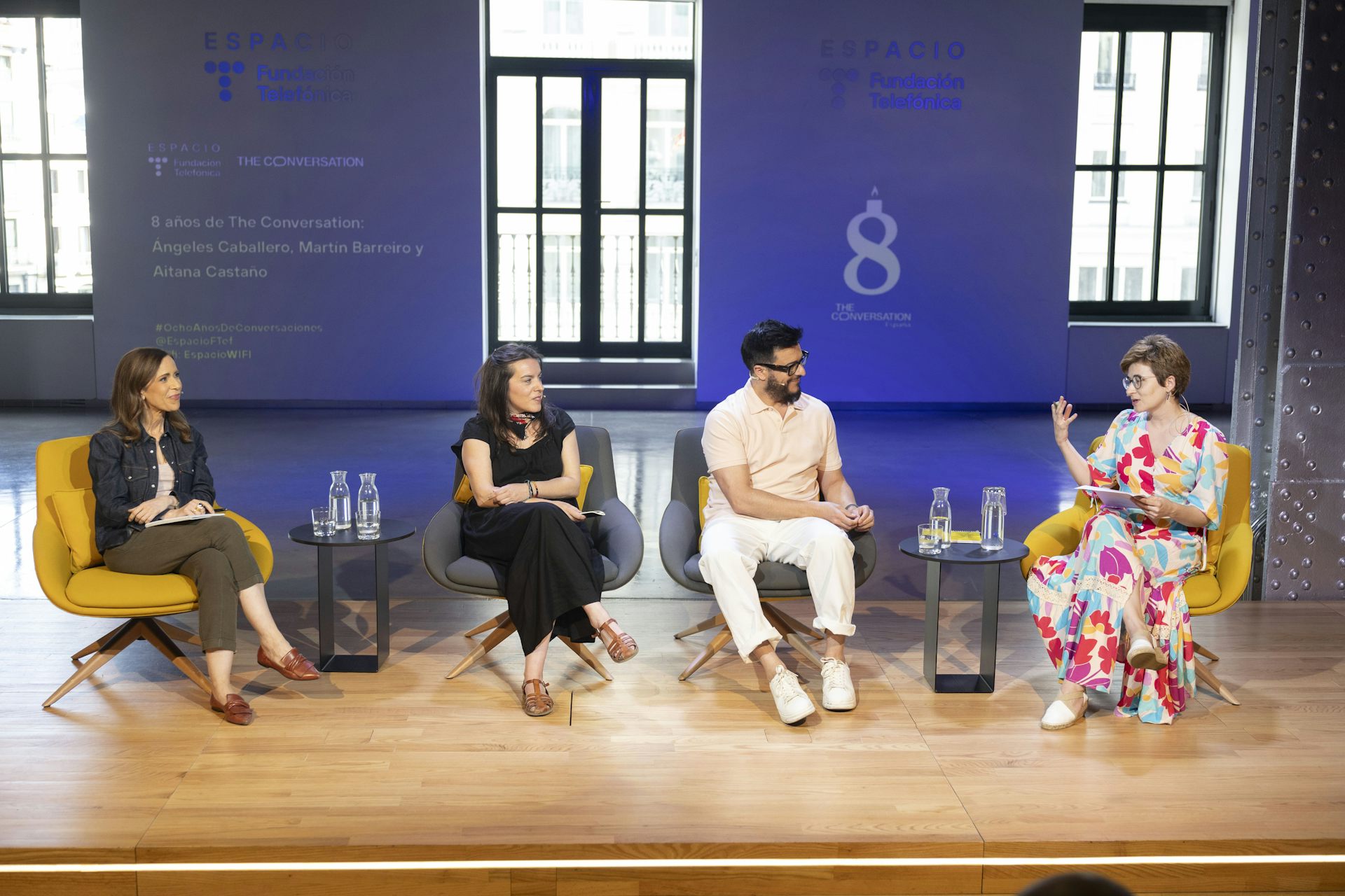 Cuatro personas hablan en el escenario.