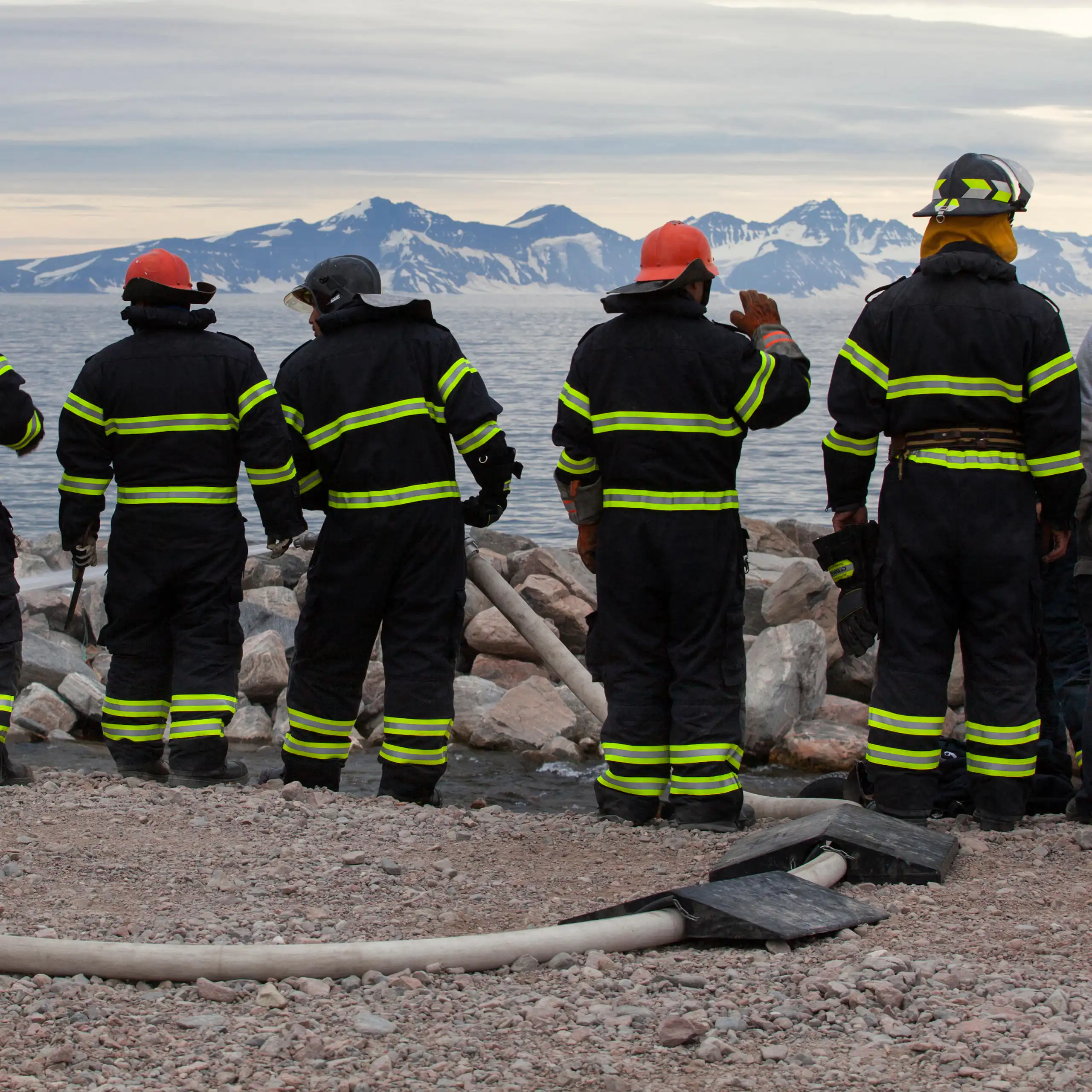 Firefighters in Greenland look across a bay towards mountains