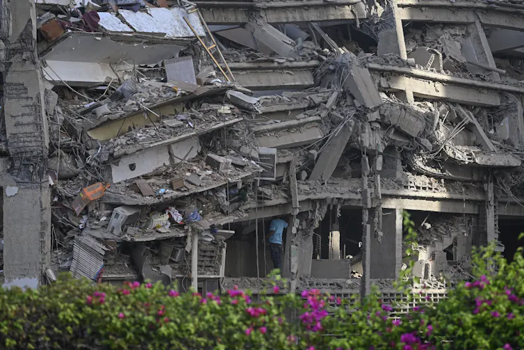 La ayuda está en camino después del terremoto en Venezuela, pero no está claro qué tan rápido podrá llegar allí. 1 Un hombre con camisa azul entra en un edificio en ruinas.