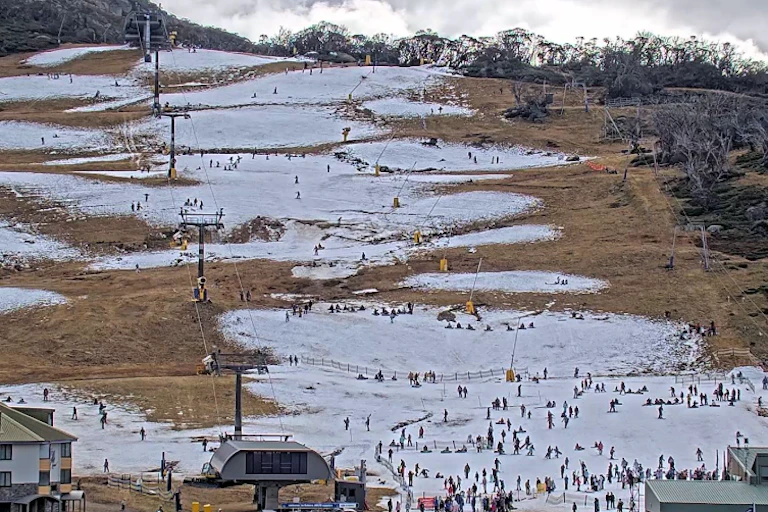 A pic of a ski run shows sparse snow and lots of clear ground.