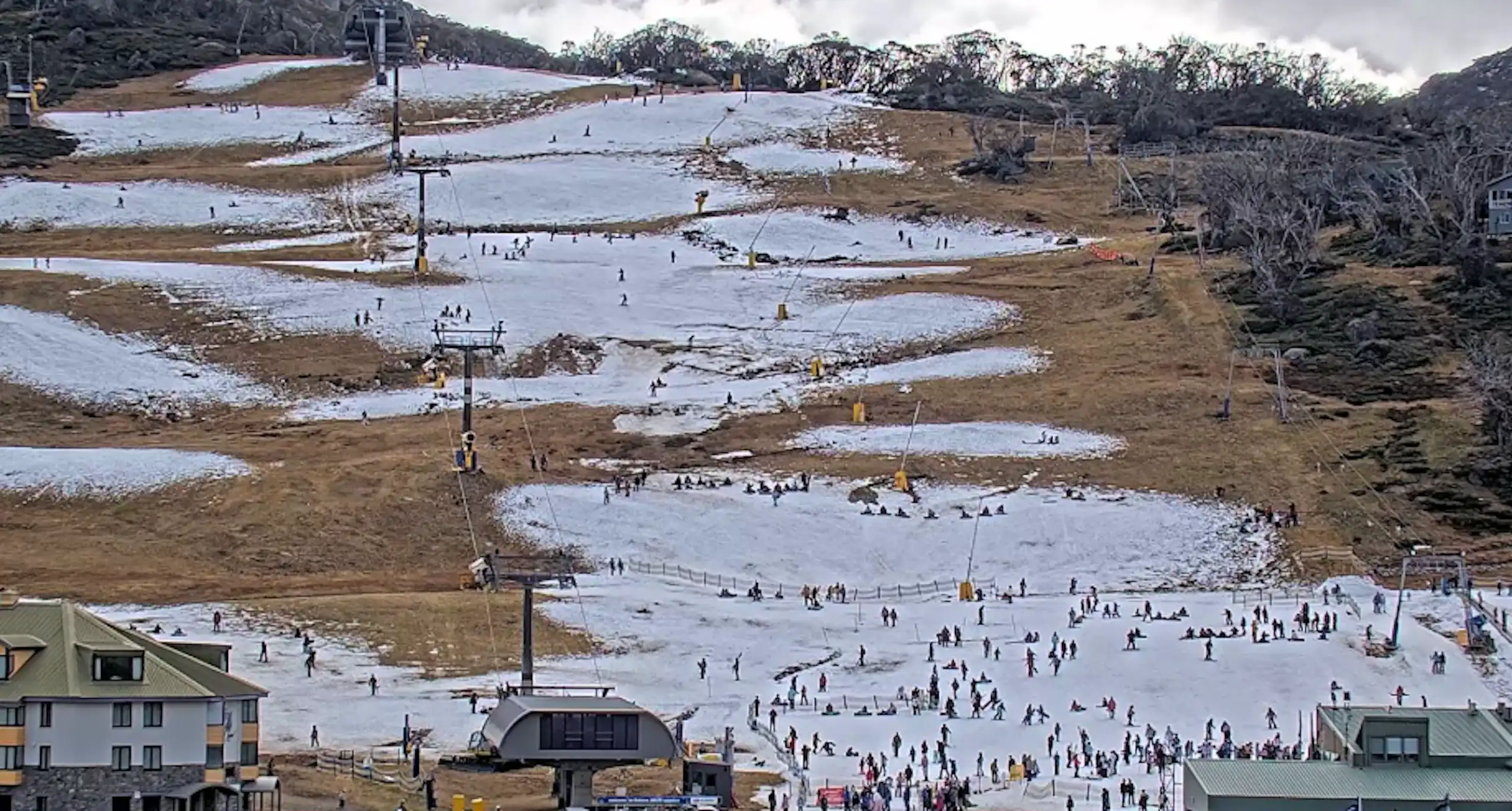 A pic of a ski run shows sparse snow and lots of clear ground.