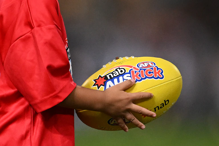 A young child is seen holding a football.