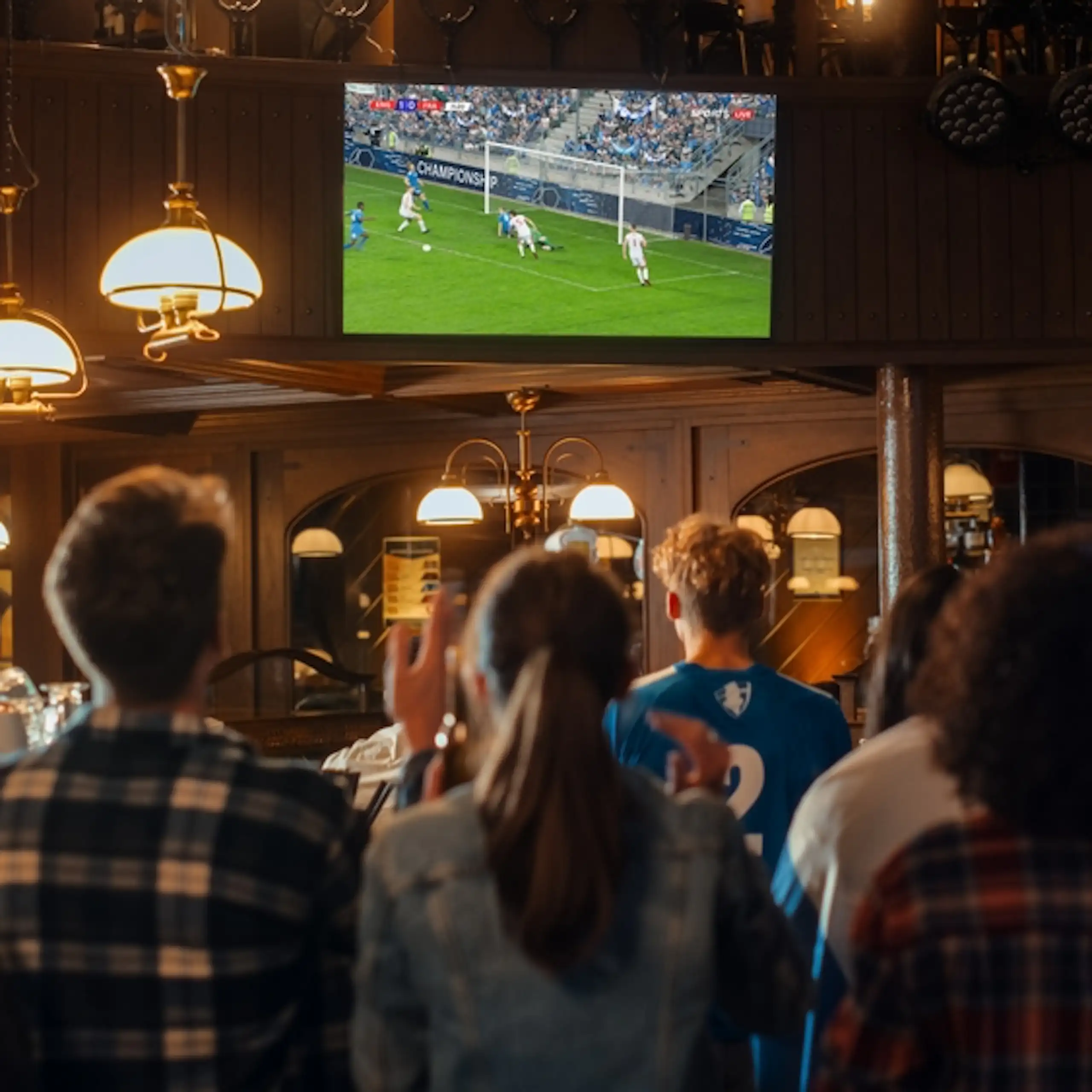 Des groupes d'amis qui regardent un match de football dans un bar