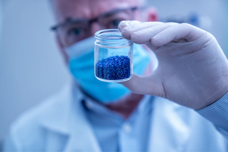 Un científico muestra un tarro con polvos azules