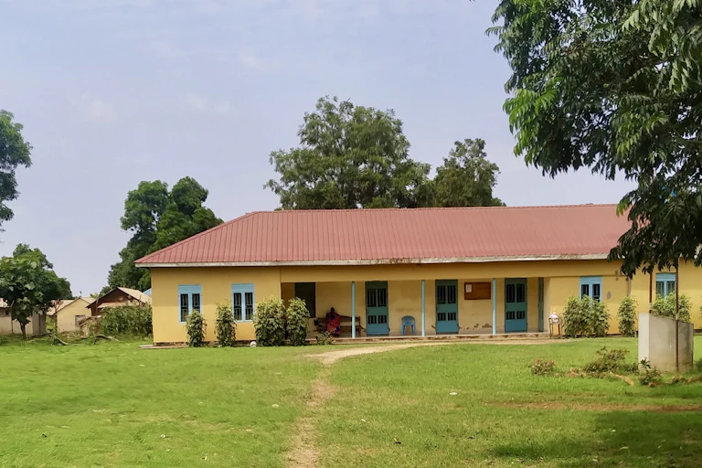 A single storey building with red roofing, yellow walls