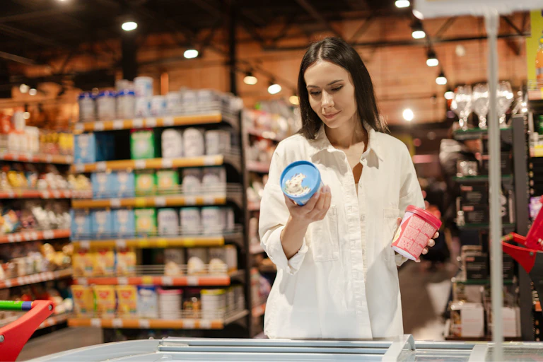 Una mujer valora dos productos en un supermercado