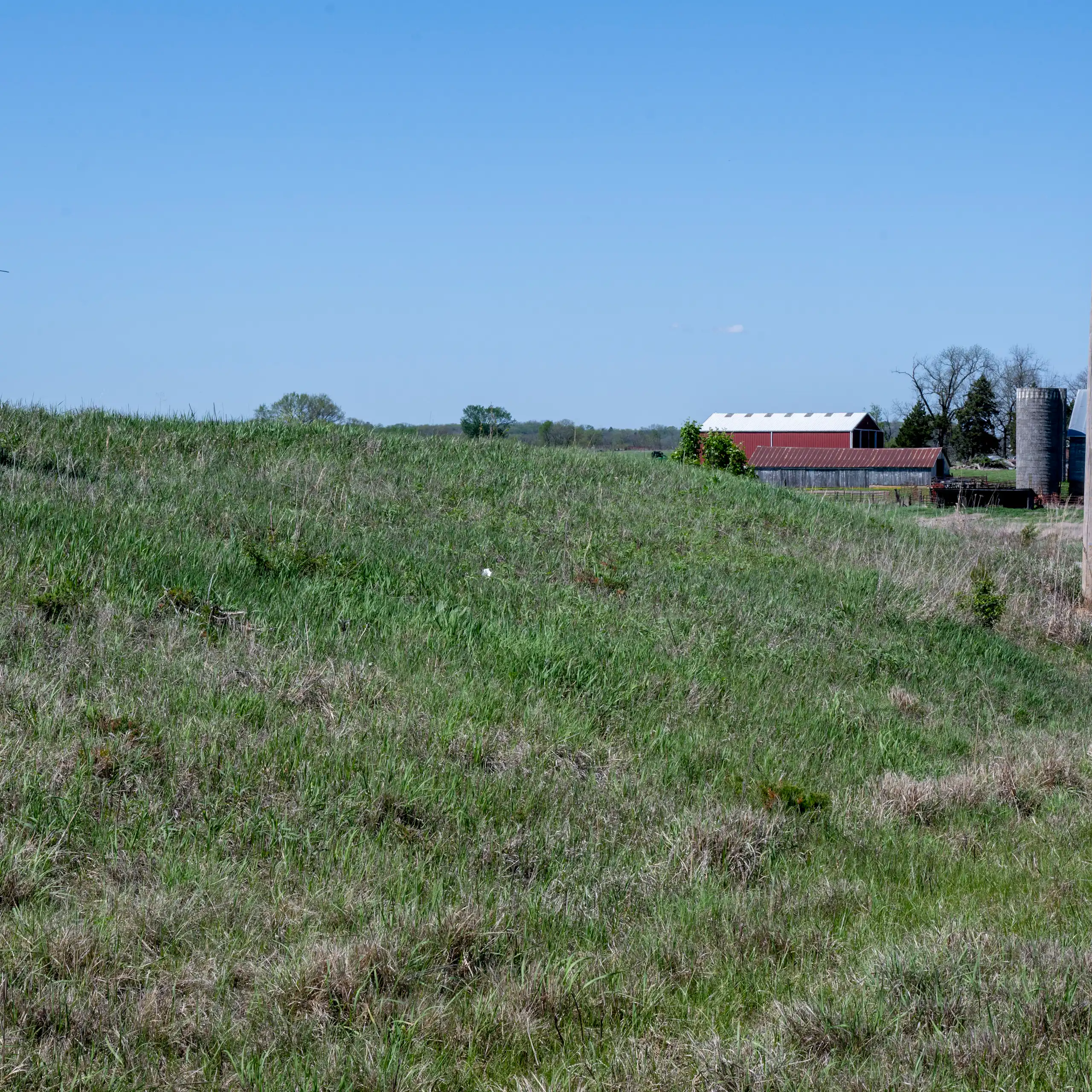 A view of open grassland with a barn and a sign reading 'No data center.'