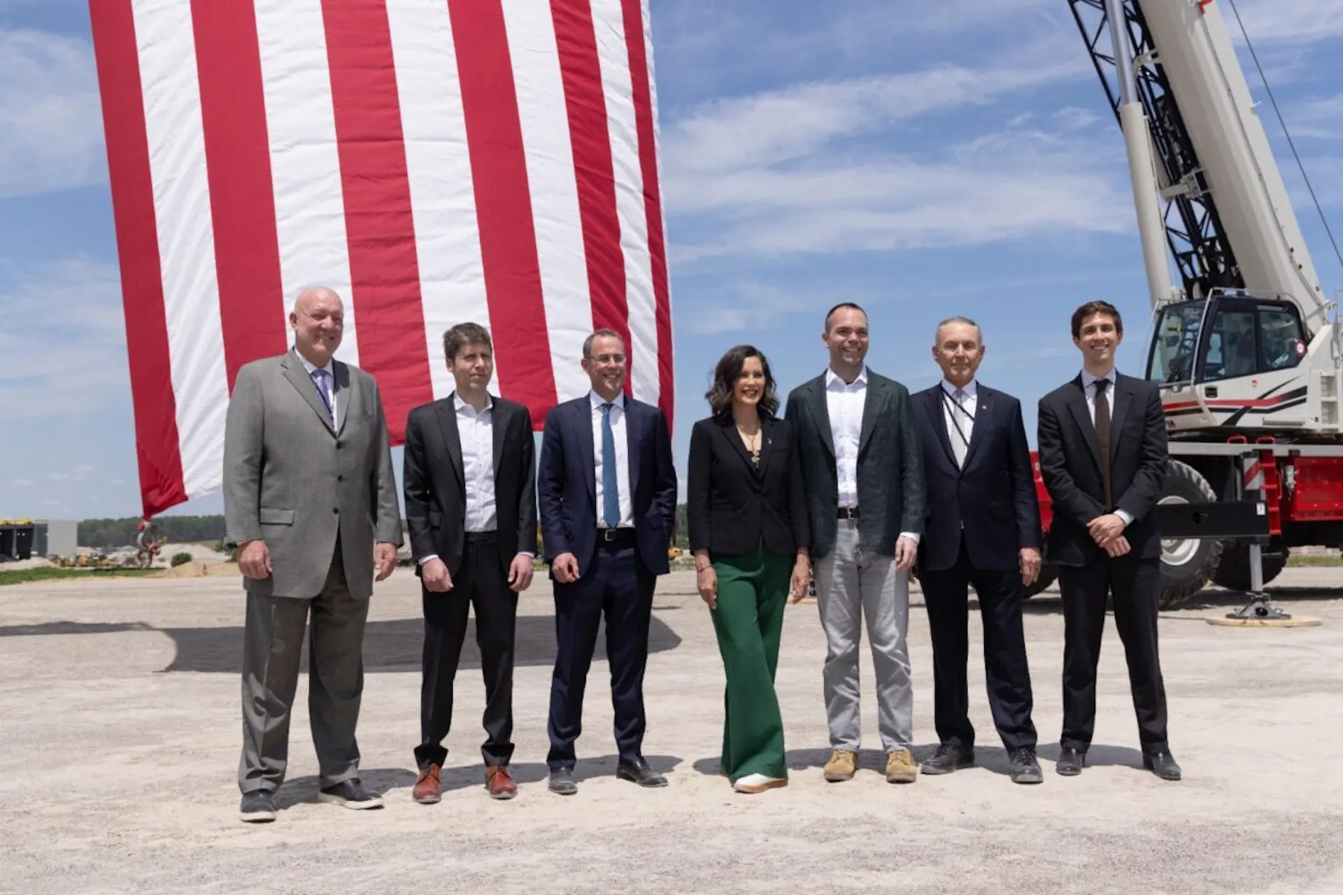 A group of people stand together on a piece of bare ground.