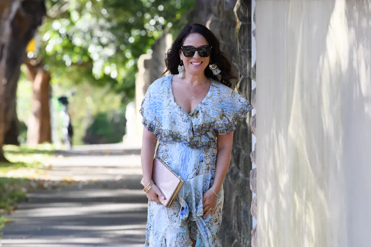 a woman in a floaty dress and sunglasses