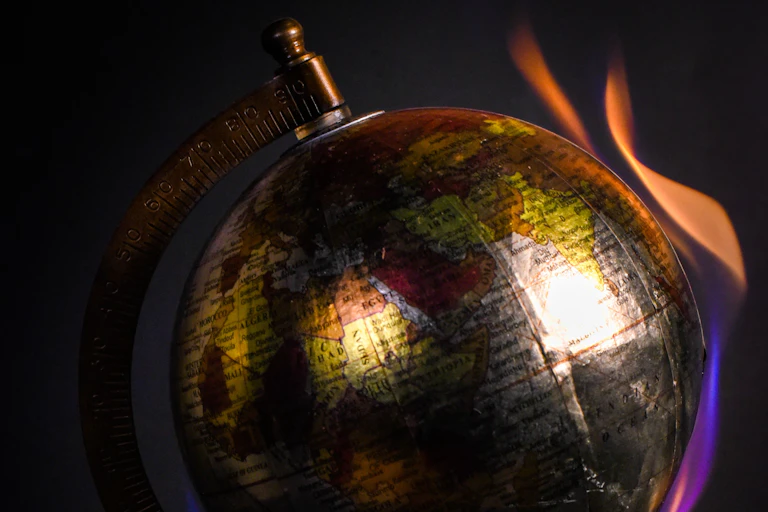 Illustration of a globe representing the Earth, with flames around it