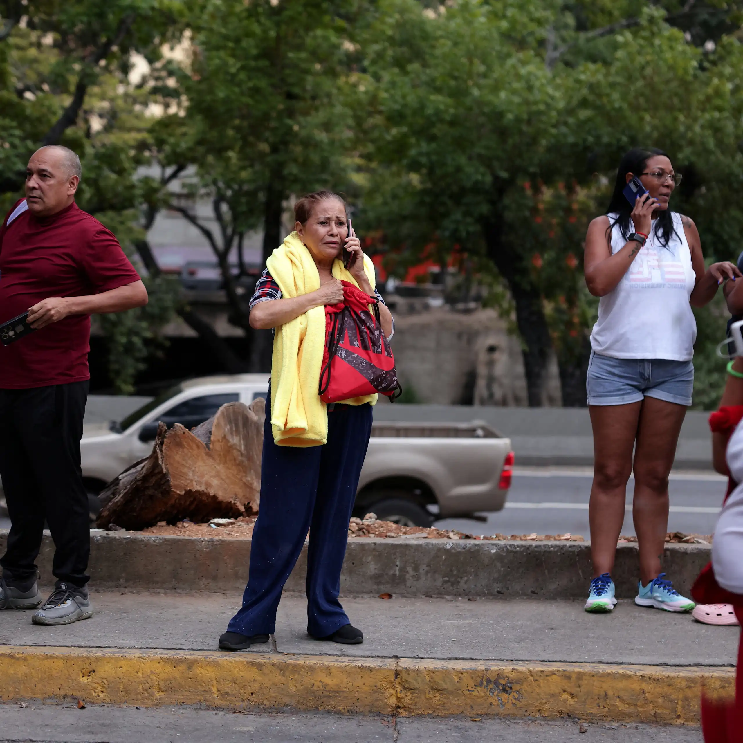 People speaking on the phone in a street.