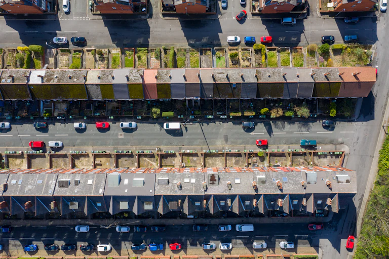 aerial shot looking down to straight streets of old houses with small gardens and cars parked