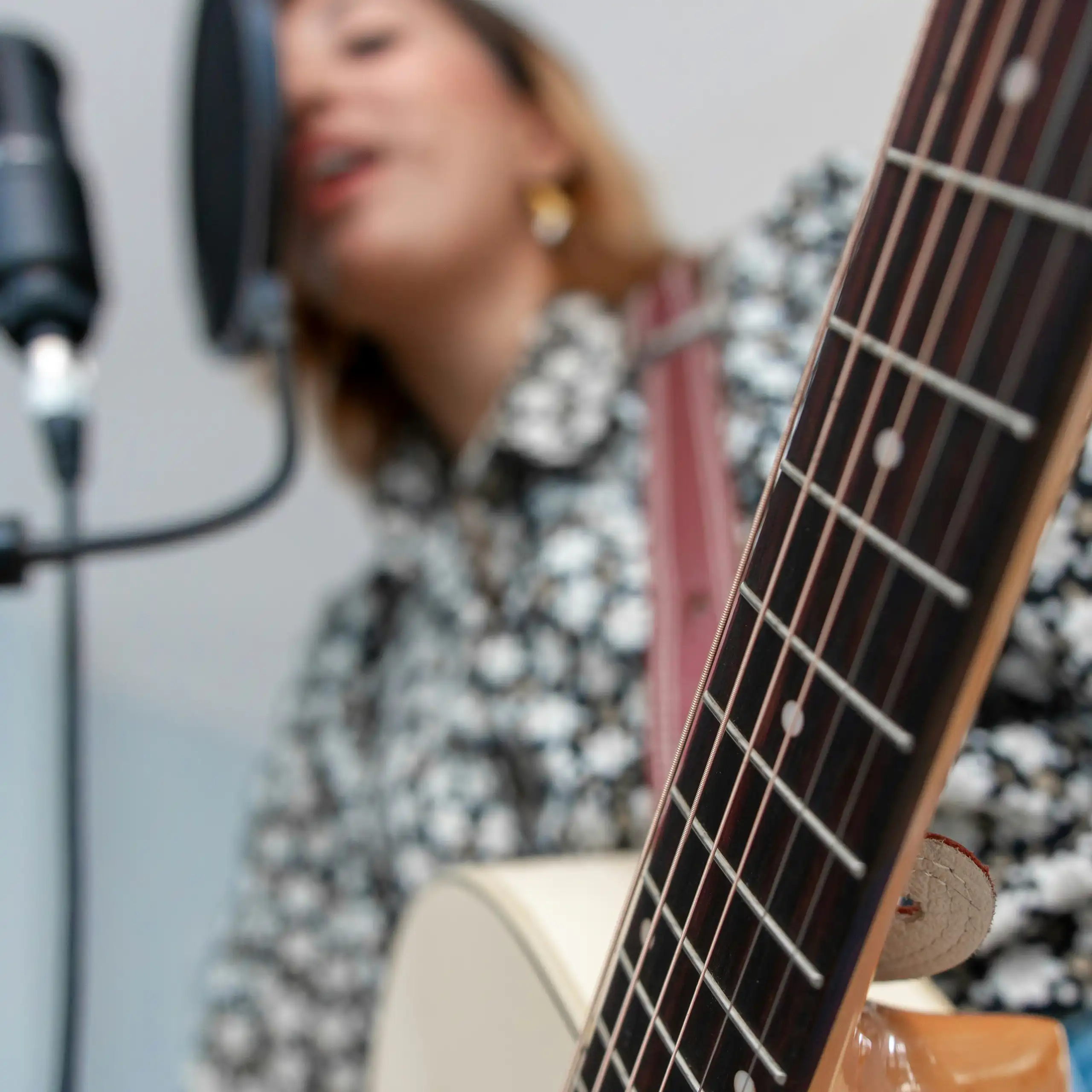 Une musicienne chante en tenant une guitare