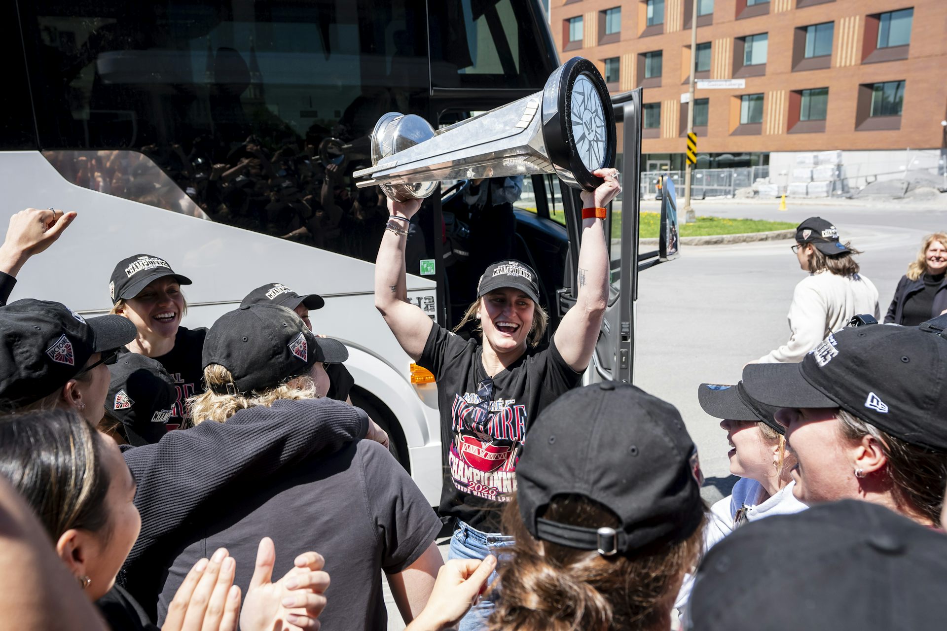 La mujer sostiene una gran copa de plata sobre su cabeza.