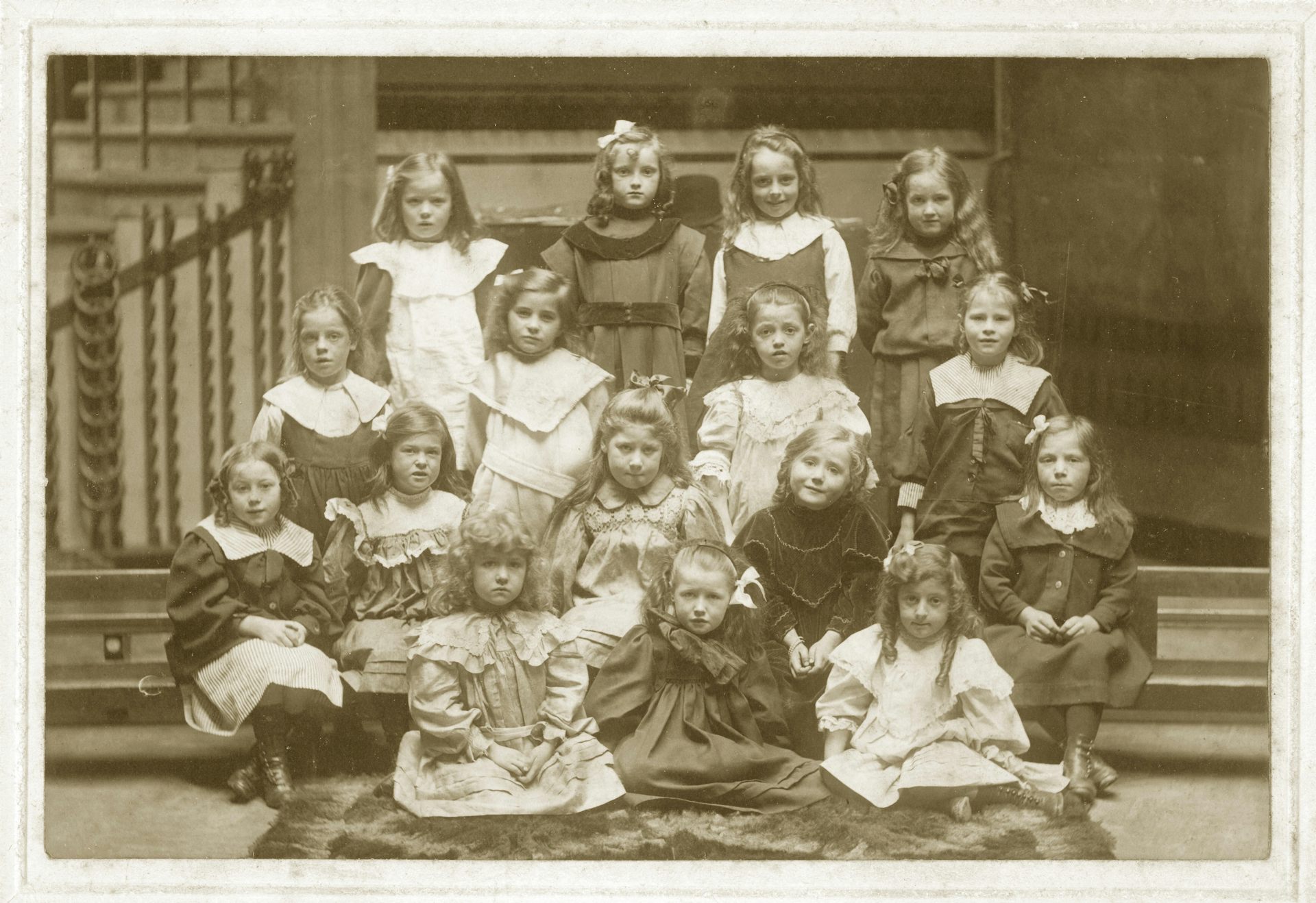 A group photo of Victorian schoolgirls arranged in rows, taken around 1900.