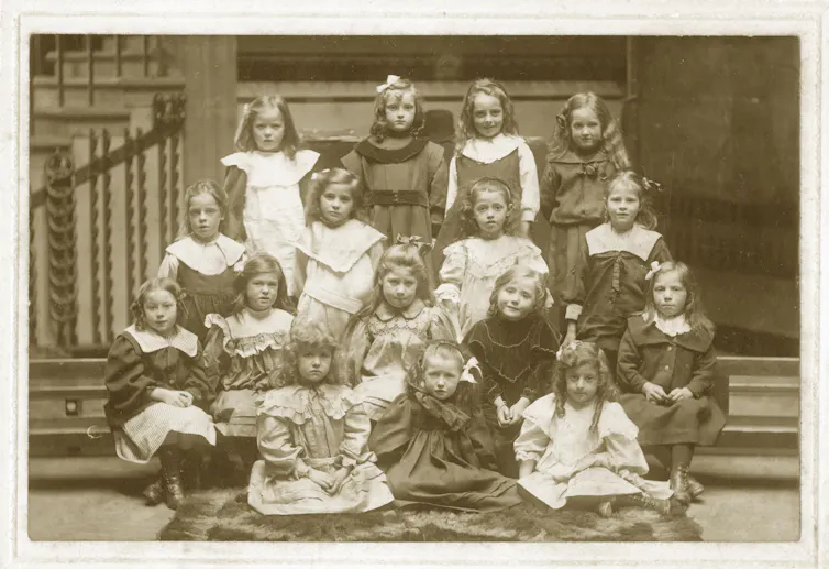 A group photo of Victorian schoolgirls arranged in rows, taken around 1900.