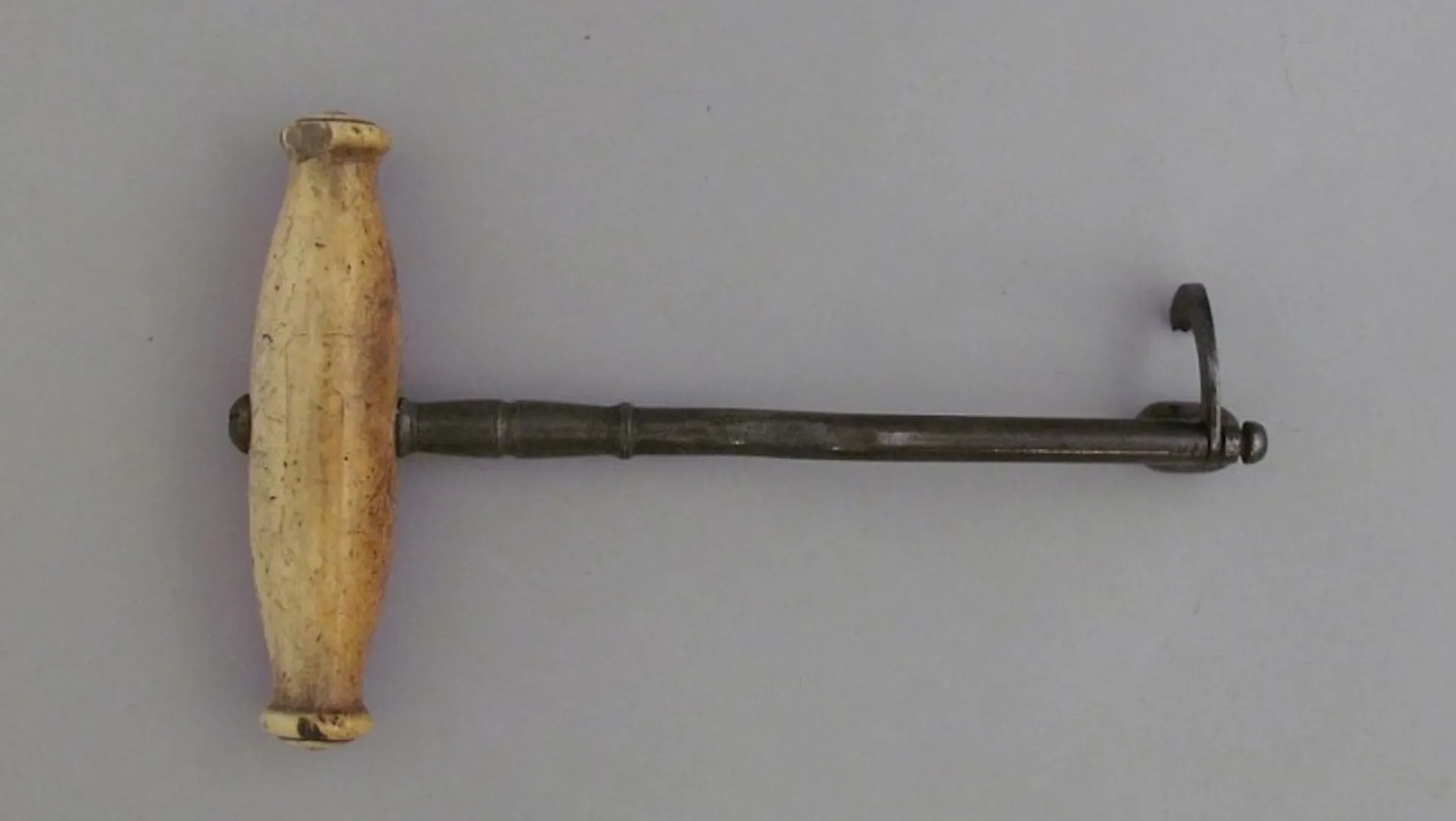 tool with wooden handle and metal hook on opposite end