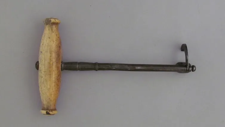una herramienta con mango de madera y un gancho de metal en el extremo opuesto