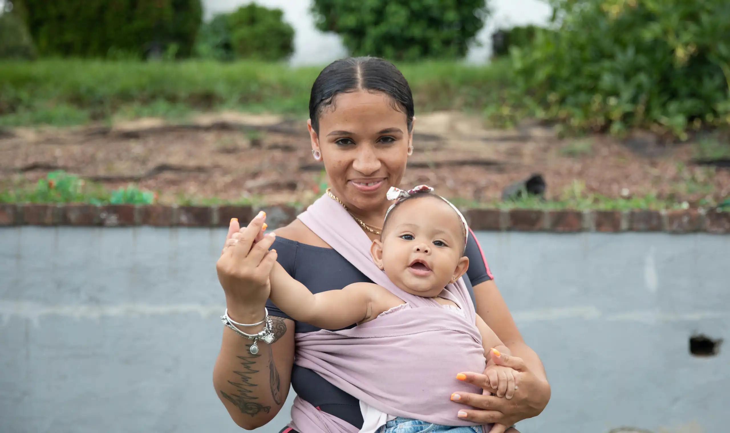 A woman with a baby strapped to her front.