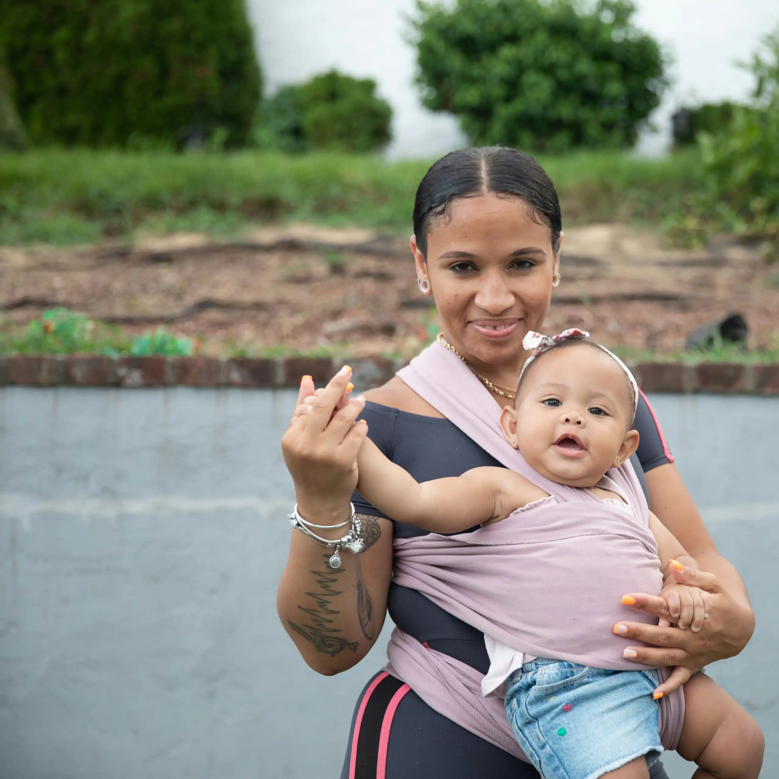 A woman with a baby strapped to her front.
