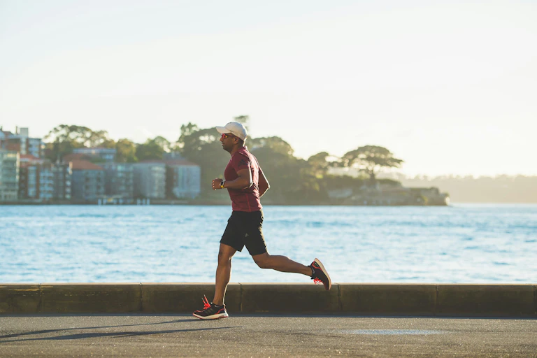 Man runs alongside harbour.