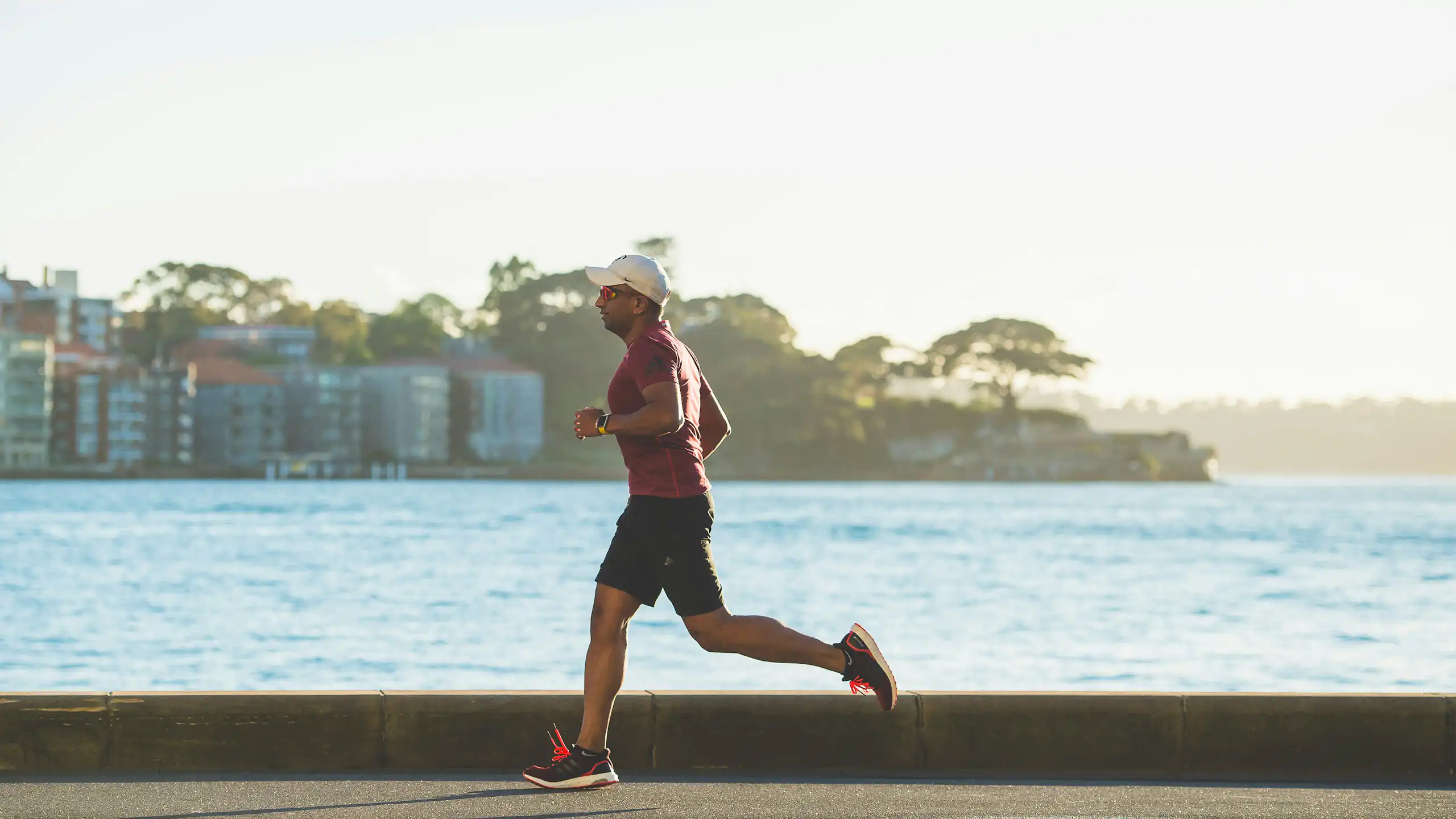 Man runs alongside harbour.