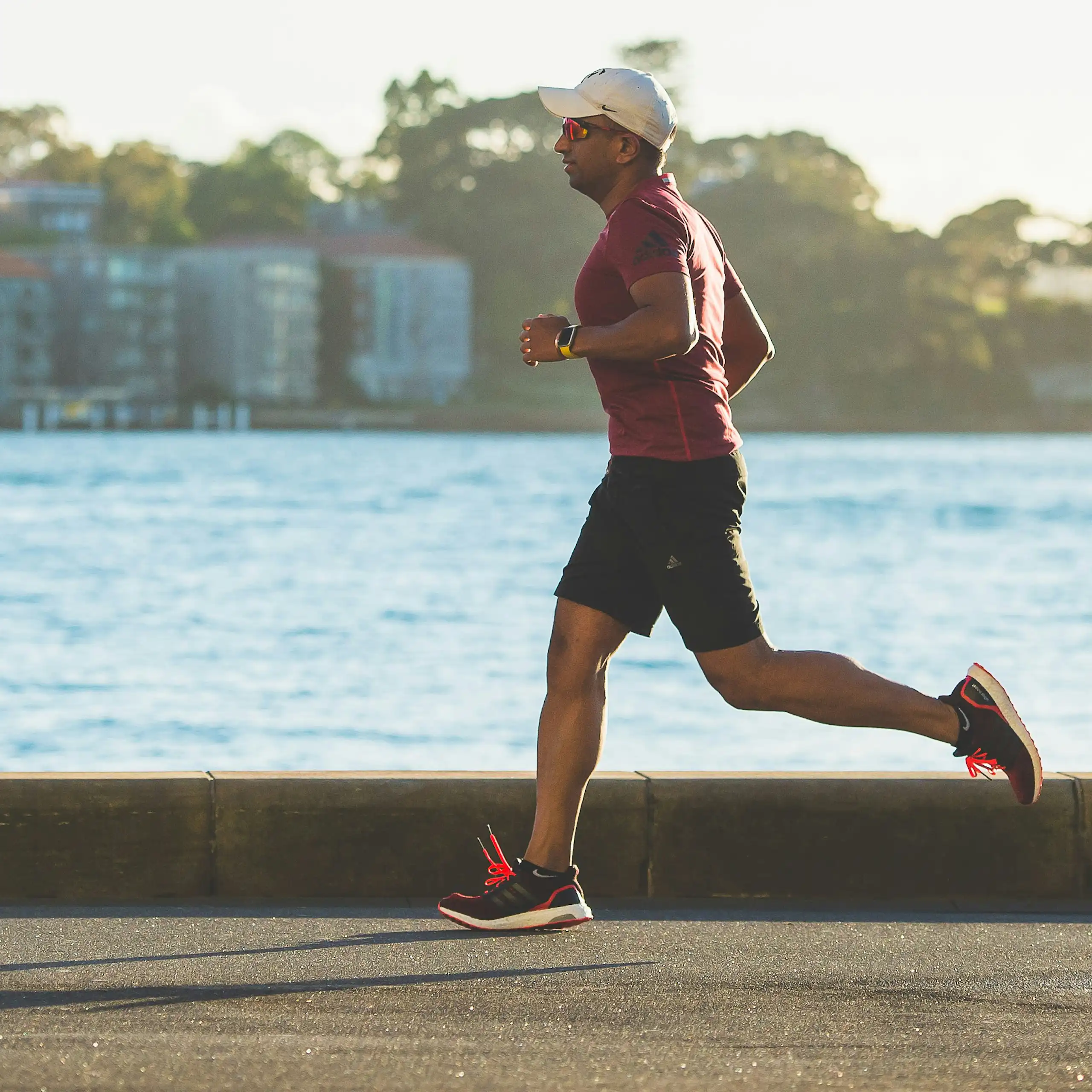 Man runs alongside harbour.