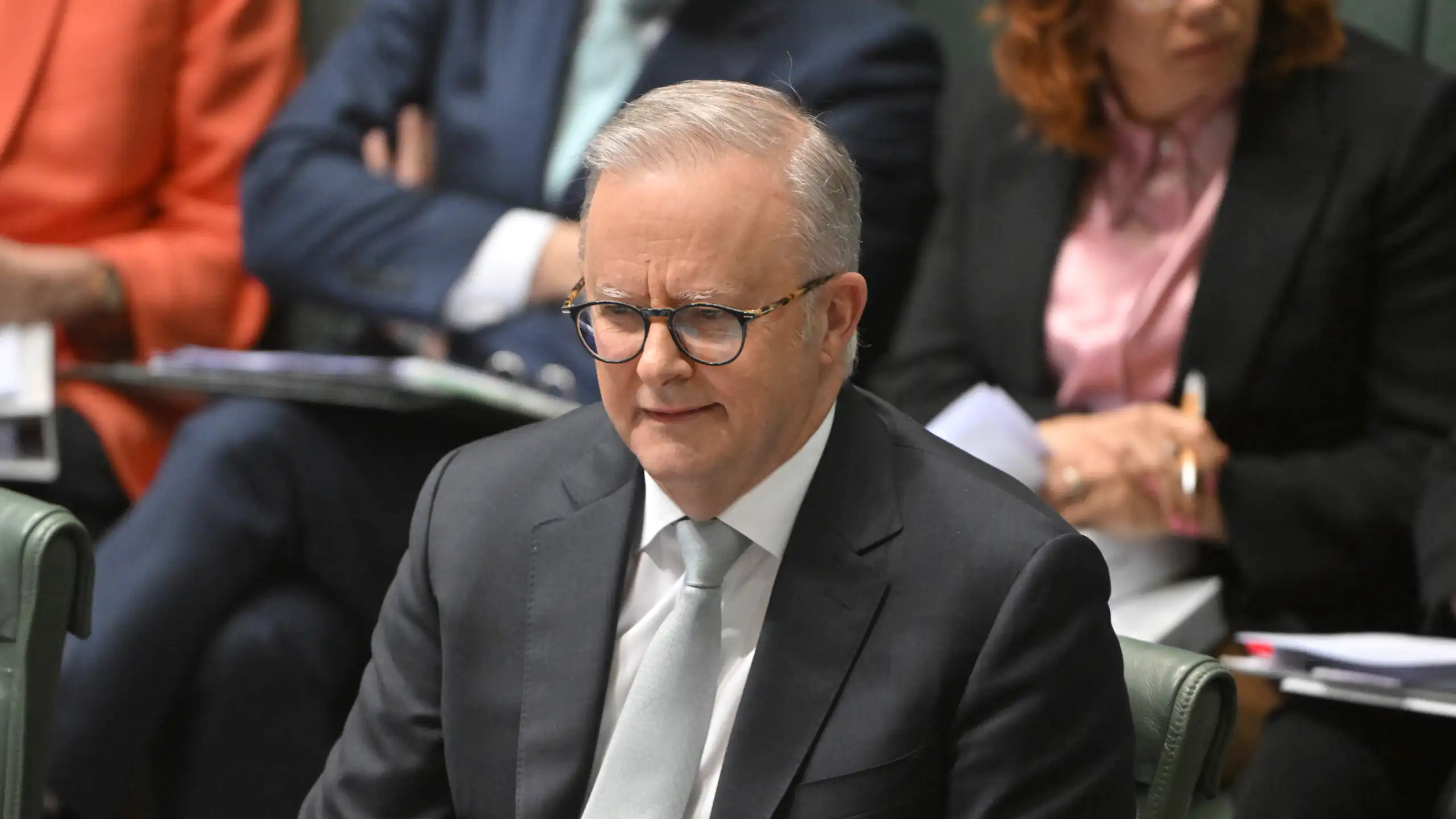 Anthony Albanese sits in parliament and smiles
