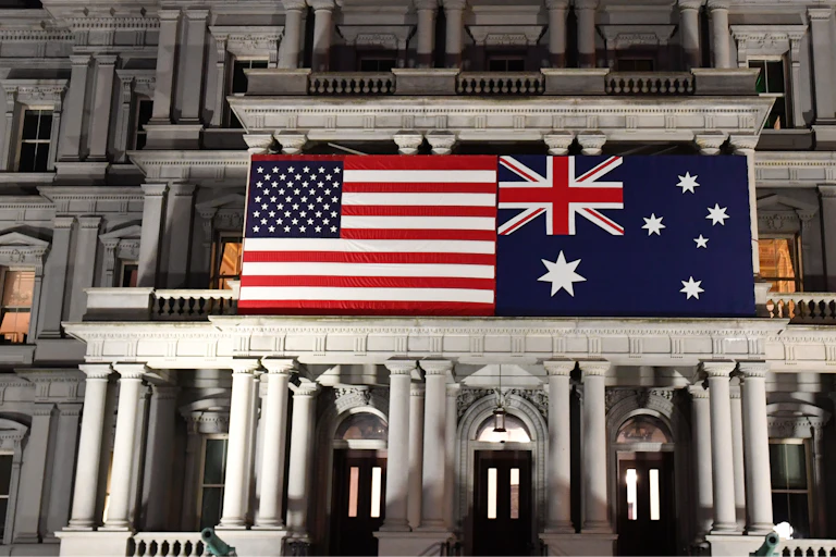 An Australian flag next to a US flag on an Edwardian building.