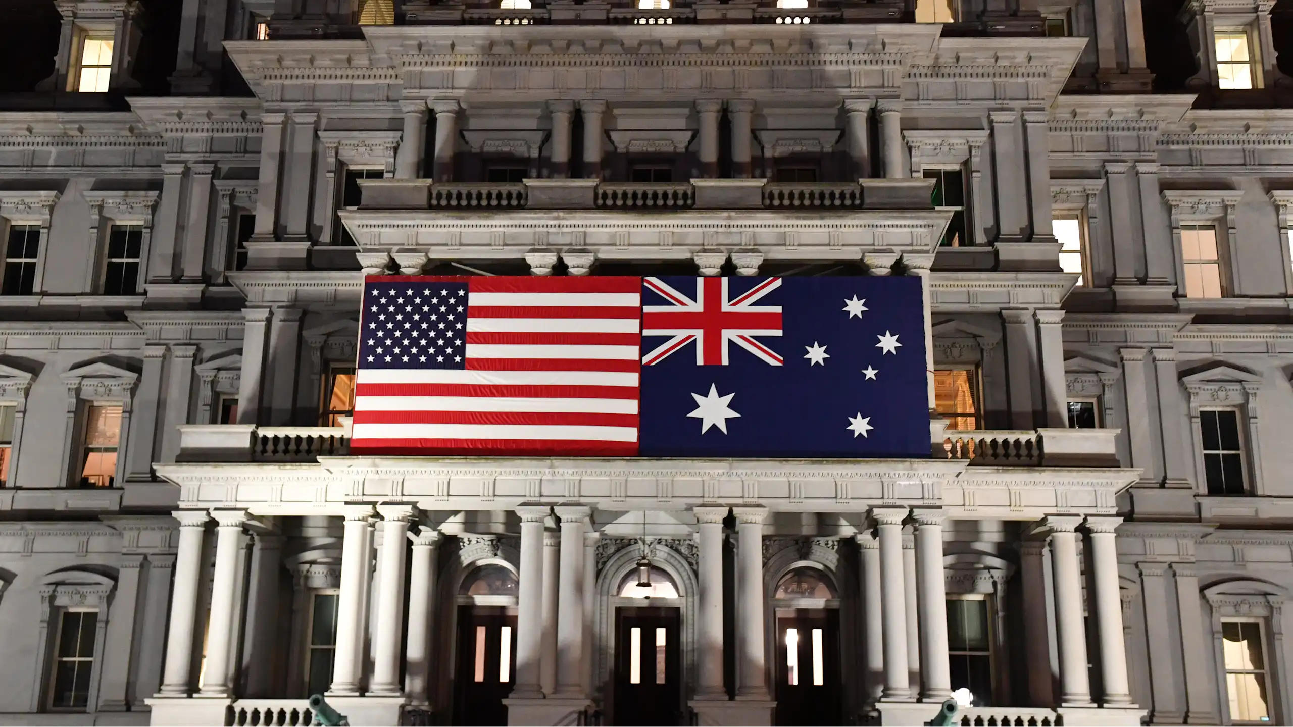 An Australian flag next to a US flag on an Edwardian building.
