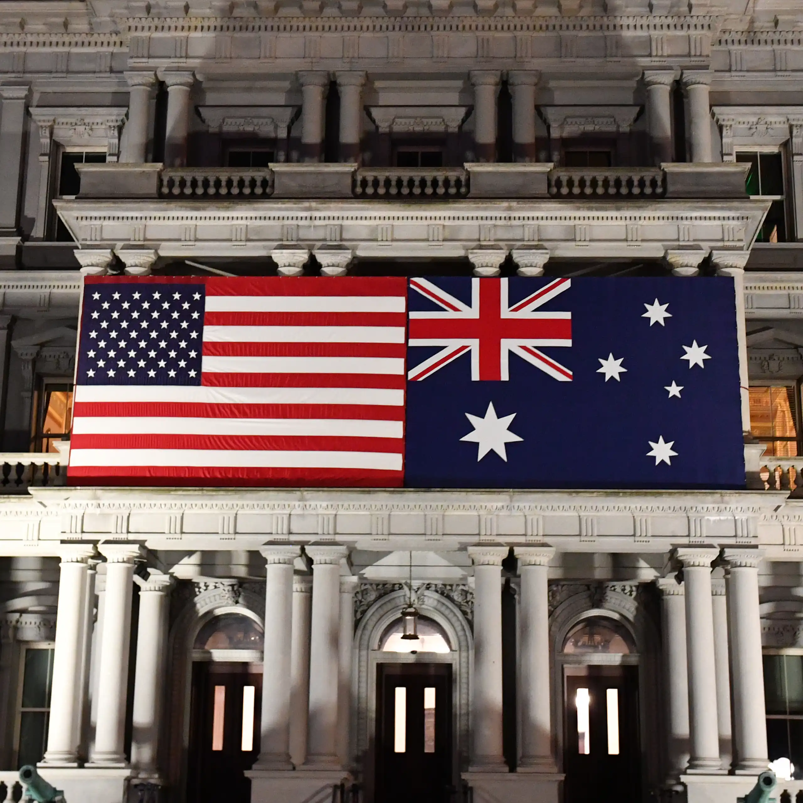 An Australian flag next to a US flag on an Edwardian building.