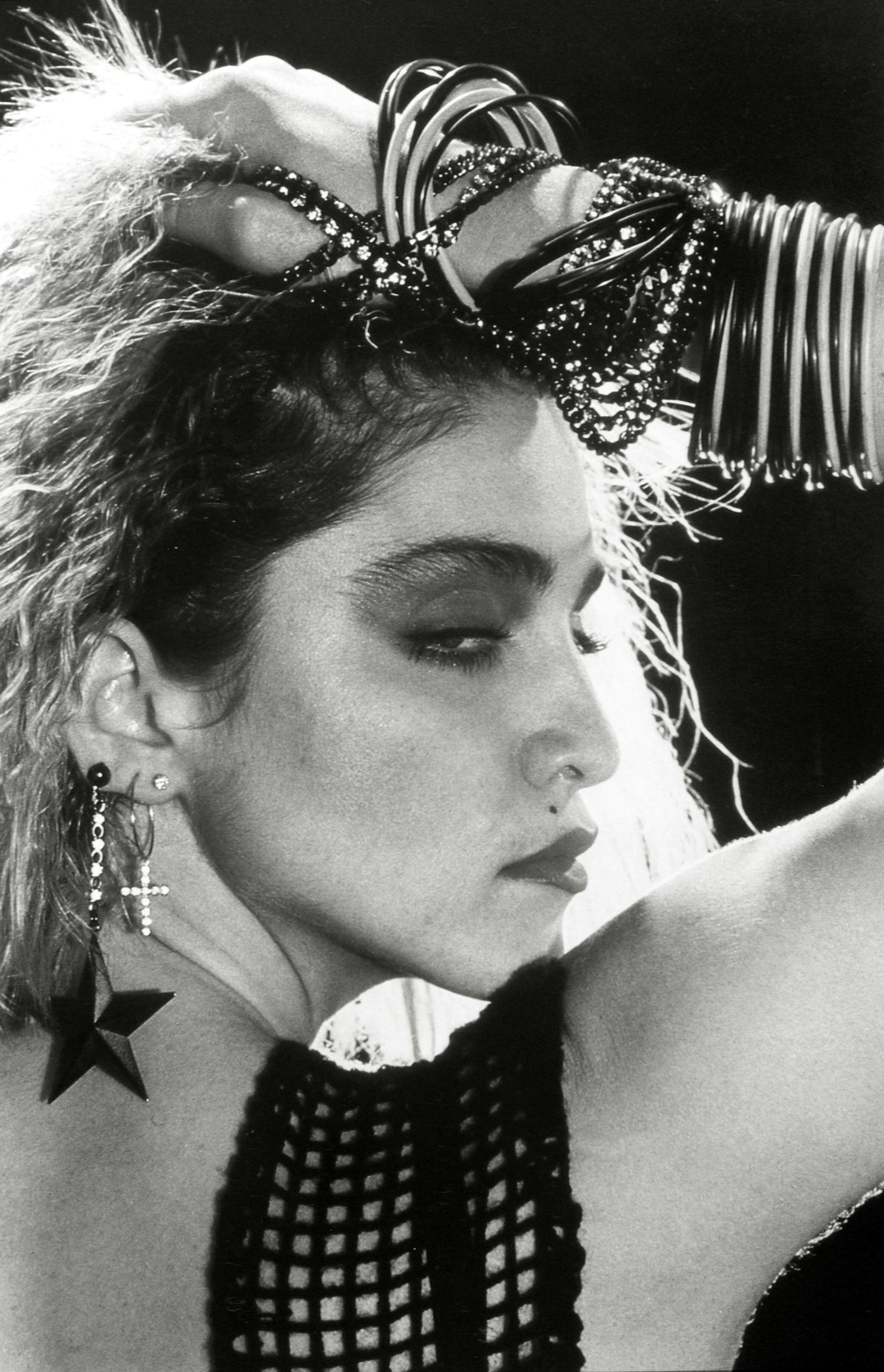 Madonna around the age of 25 wearing lots of cheap bangles and earrings.