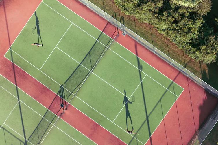 aerial view of green tennis court with one player on each side